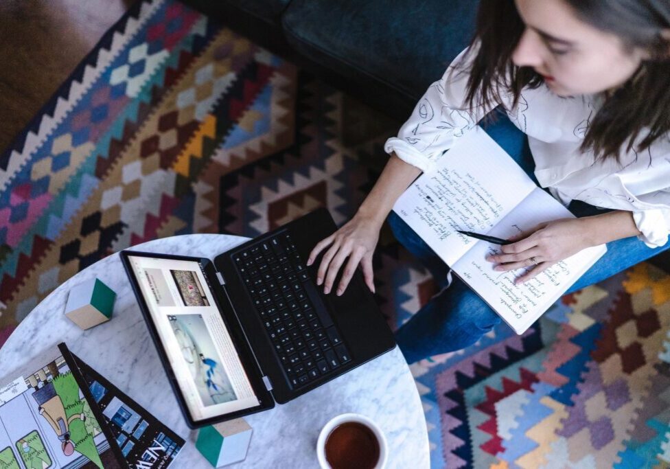 A woman sitting on the floor with her laptop.